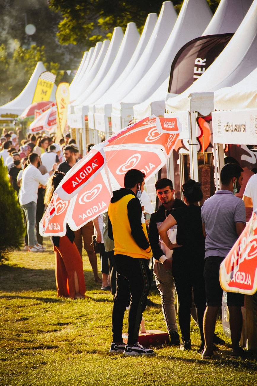 busy people standing near the tents on the street