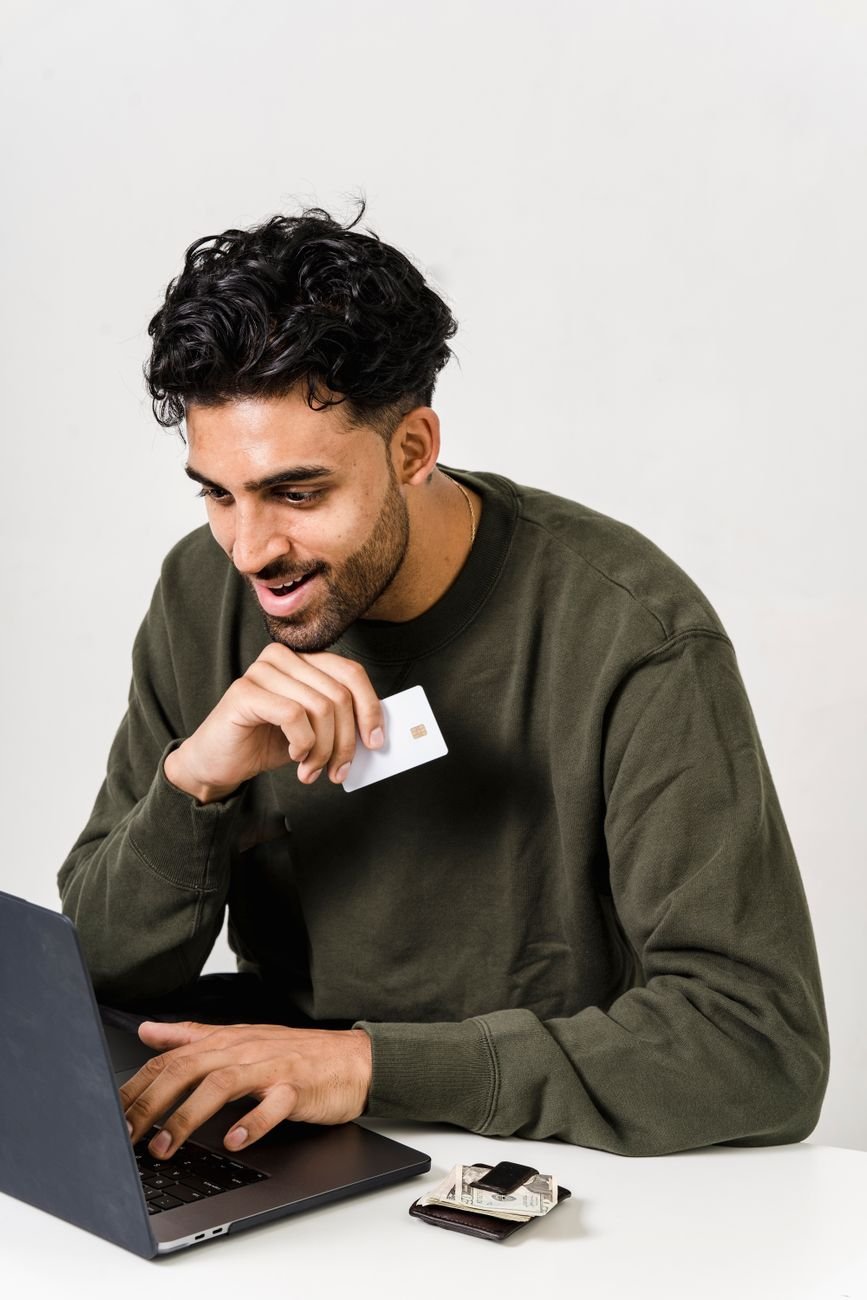 man in green sweater holding a white card
