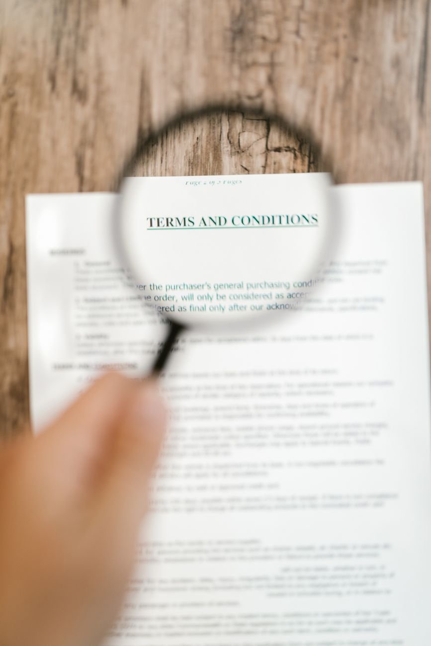 person holding a magnifying glass above a document